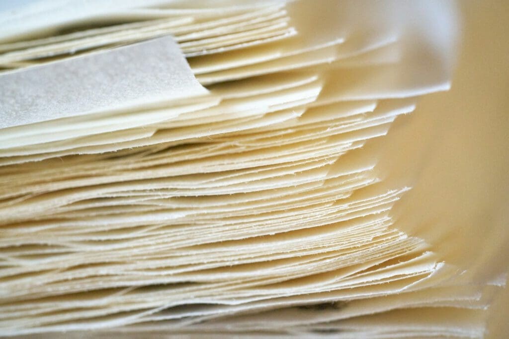 Here is a caption for the image: a stack of thin, layered paper.